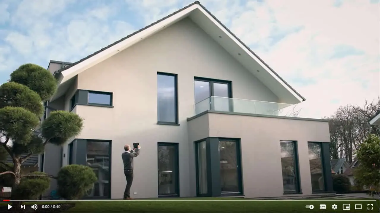 Mann fotografiert sein Haus