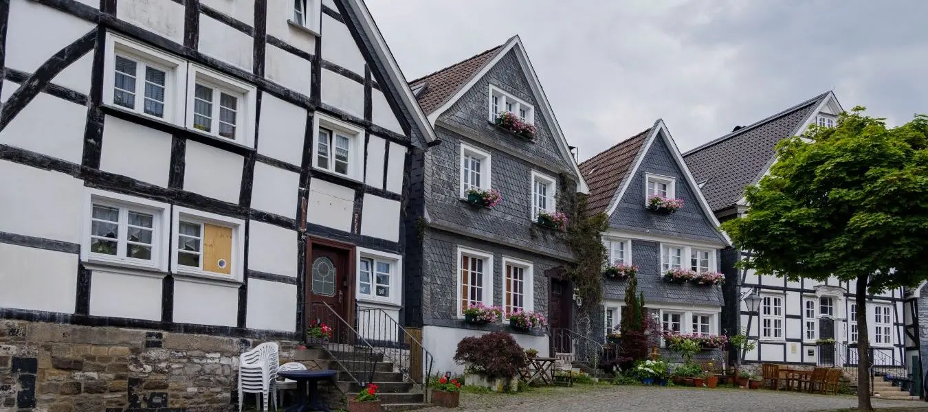 Outdoor street view of small town with traditional German wooden townhouses around Neviges Church in Velbert, Germany.