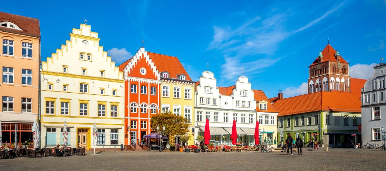 Blick auf den Marktplatz in Greifswald: Bunte Fachwerkhäuser und Kopfsteinpflasterstraße  