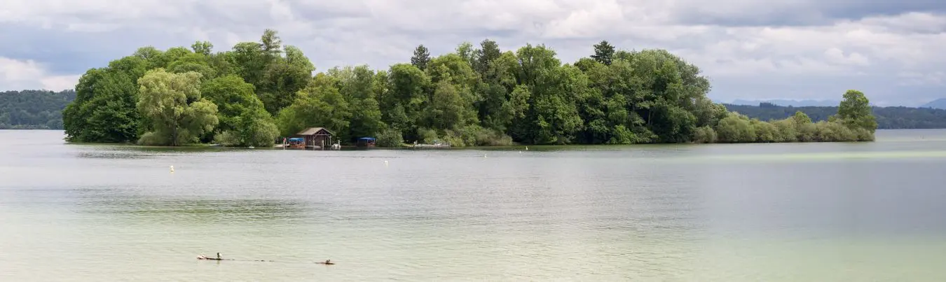 FELDAFING, BAVARIA / GERMANY - June 16, 2019: Panorama view of the Roseninsel (rose island) at Lake Starnberg. Famous rose garden. The pile dwellings around the island are an Unesco World