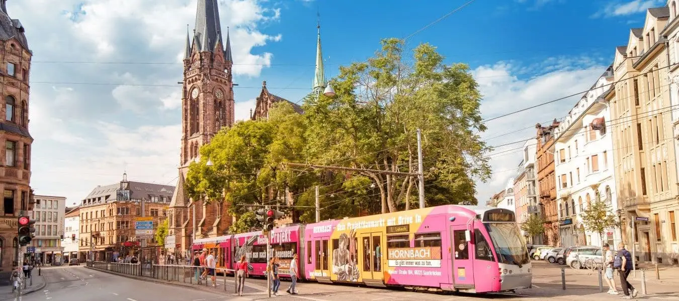  Saarbrücken: Straßenbahn im Stadtverkehr mit Johanneskirche im Hintergrund