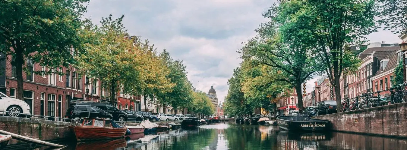 Blick auf einen Kanal in Amsterdam, umsäumt von typischen Grachtenhäusern