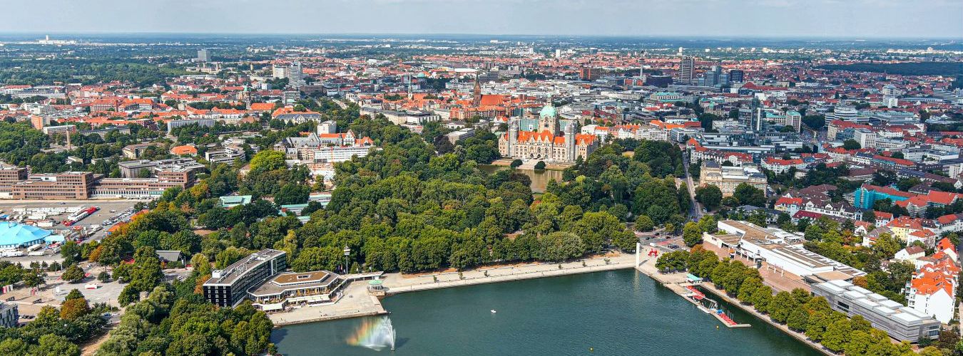 Neues Rathaus und Hannovers Stadtzentrum aus der Luft, Deutschland, Europa. Luftaufnahme aus der Flugzeugperspektive mit Blick auf den Maschsee und die Parks rund um Hannover-Mitte, dem historischen Herzen der Stadt