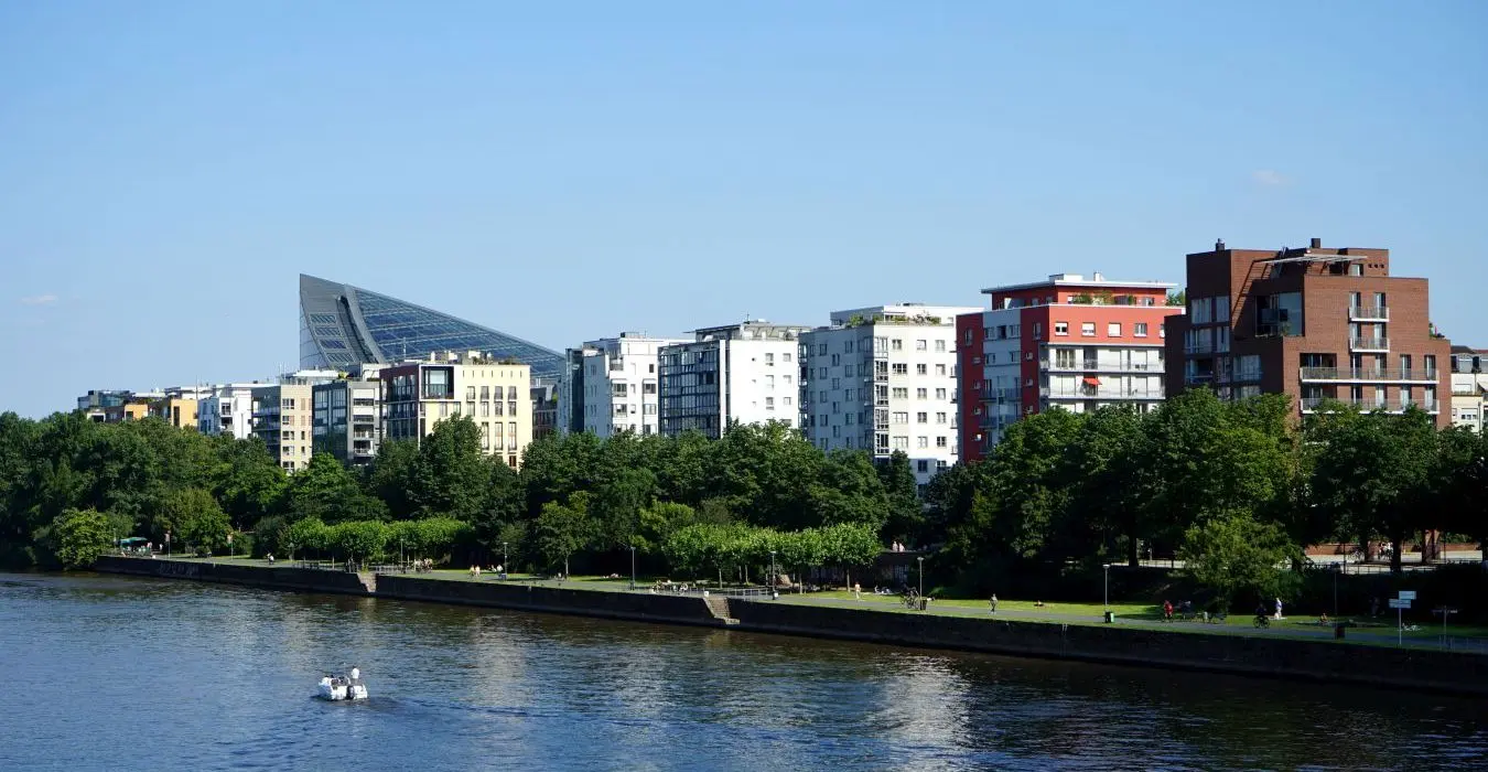 Moderne Wohnhaus Architektur mit viel Grün am Deutschherrnufer vor blauem Himmel im Sommer bei Sonnenschein im Stadtteil Sachsenhausen in Frankfurt am Main