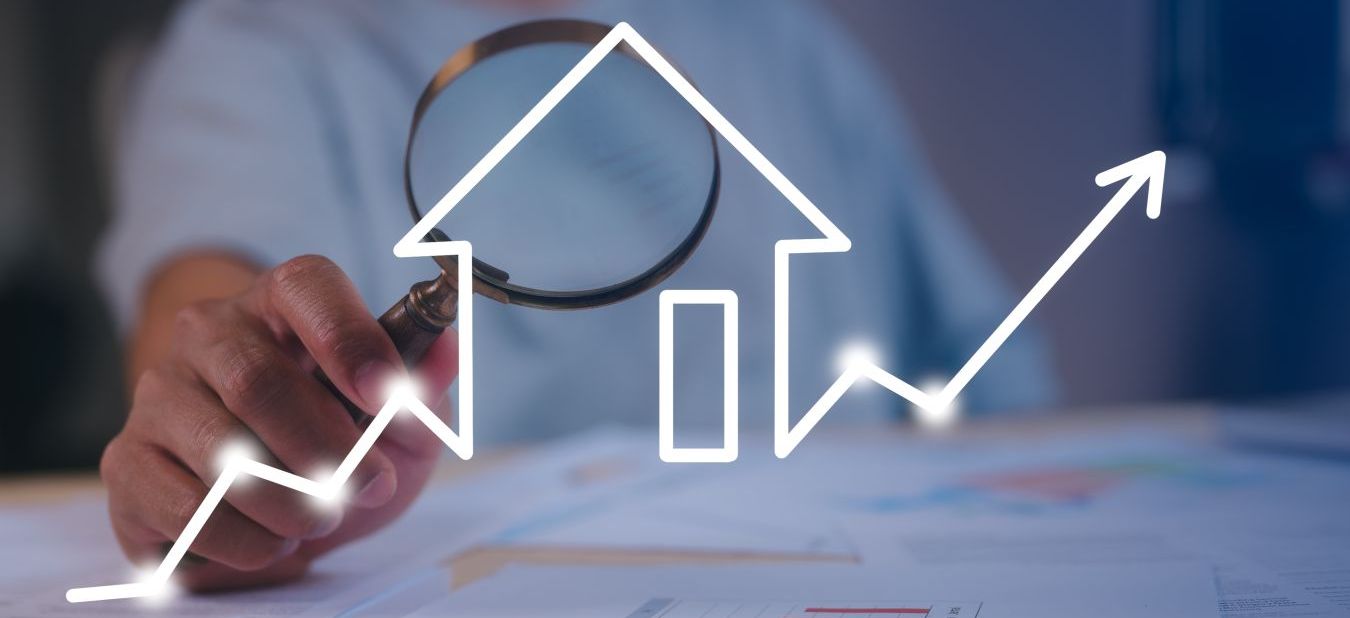 Ein Investor untersucht Immobilienmarkttrends mit einer Lupe