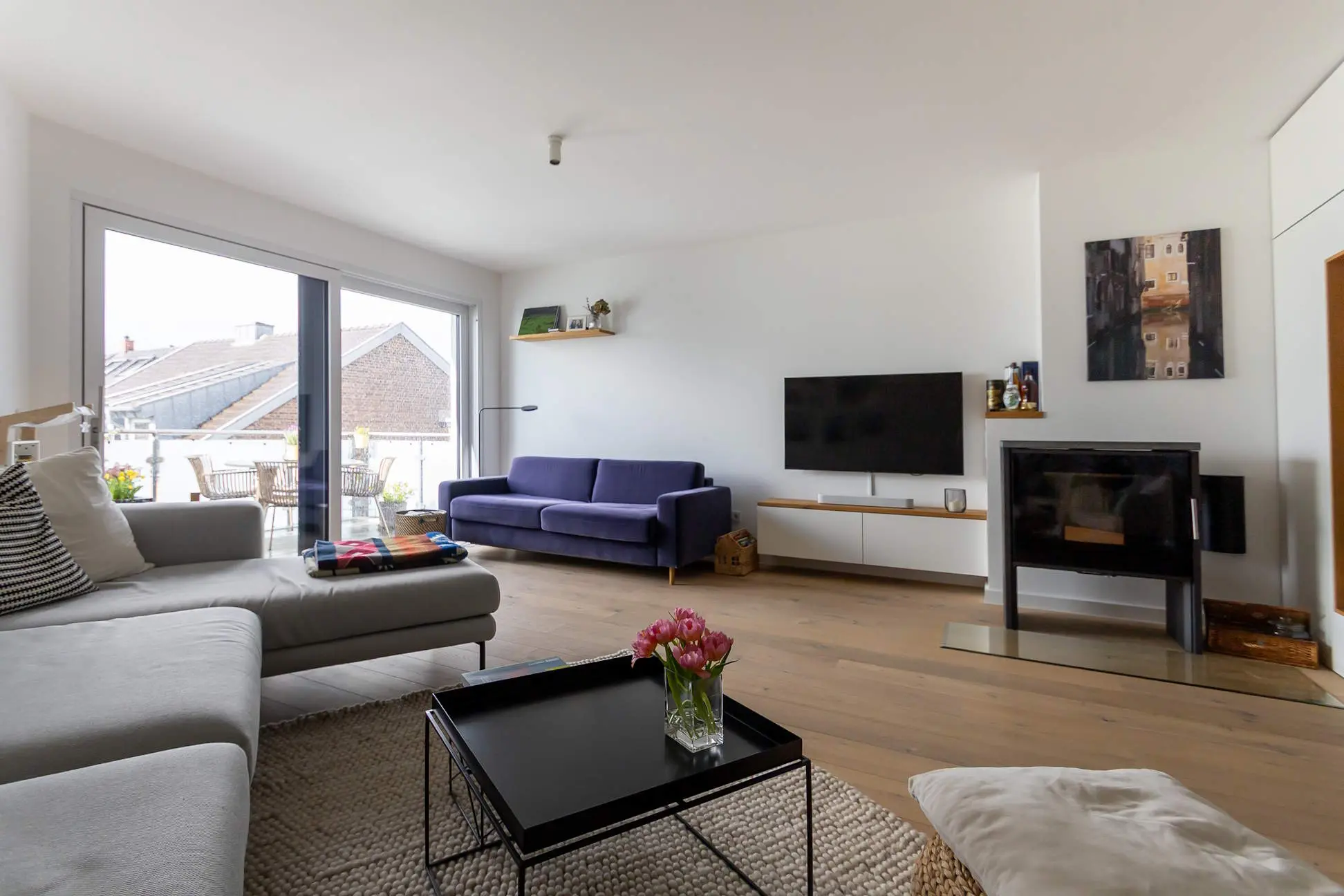 schön eingerichteter Wohnraum mit Fernseher und Kaminofen