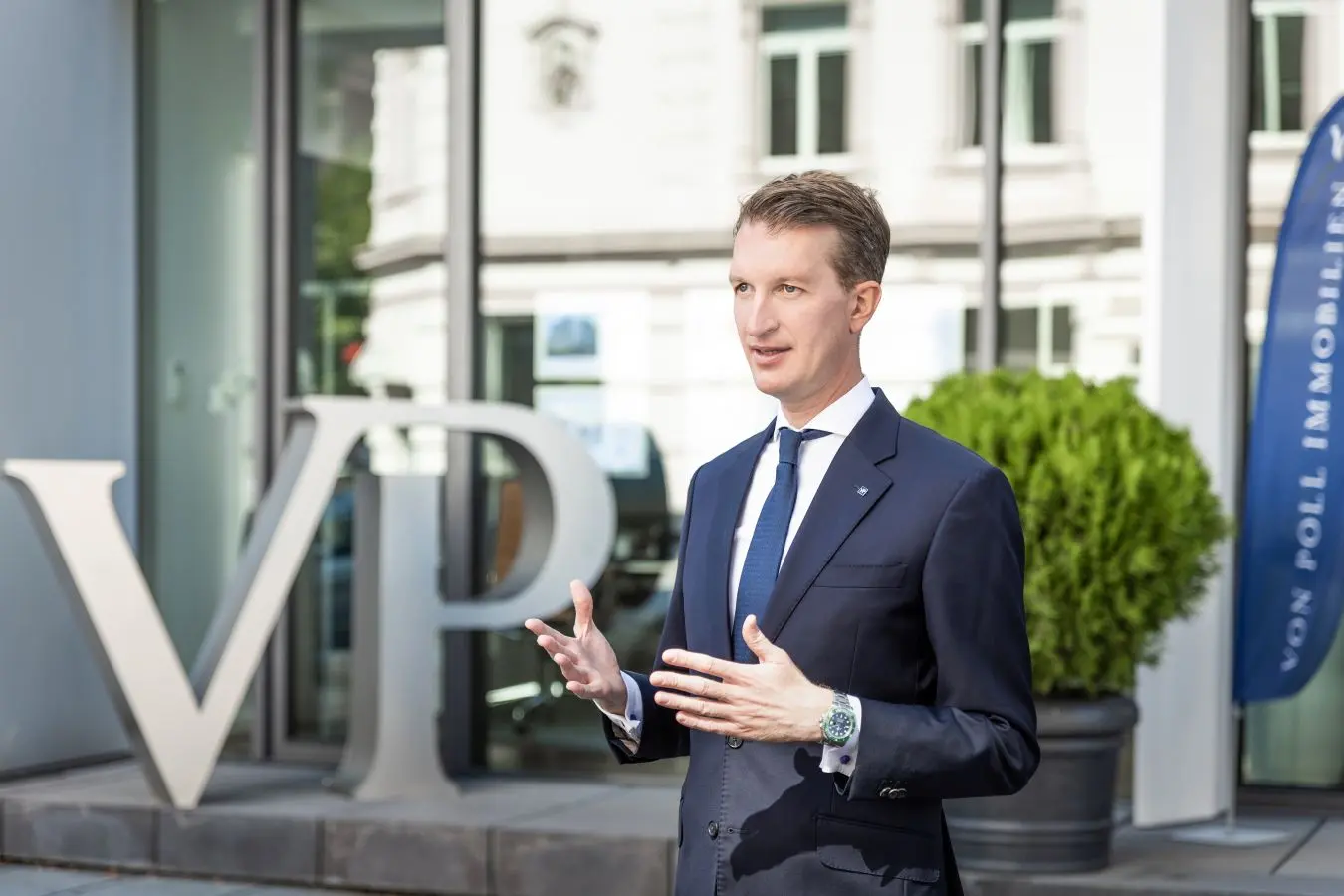 Tim Wistokat vor dem Eingang der VON POLL IMMOBILIEN Zentrale in Frankfurt am Main
