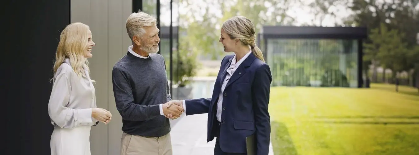 Un agent immobilier serre la main d'un couple