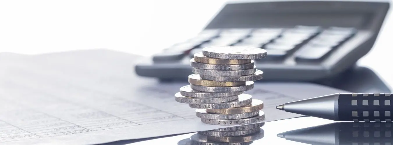 Finances, euros, piles de pièces sur des tableaux avec stylo et calculatrice