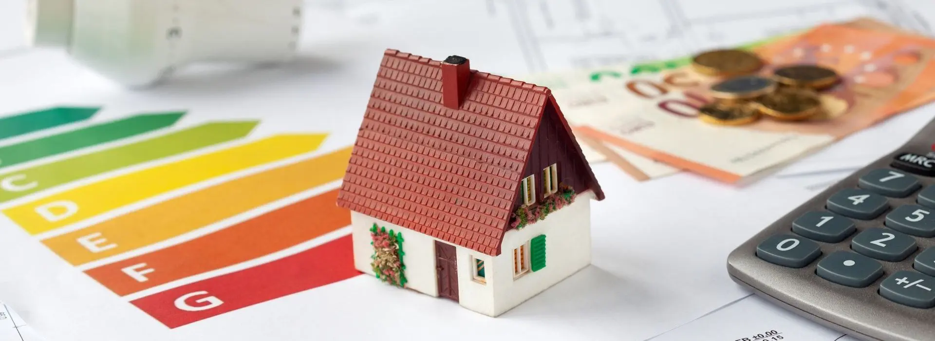 Image symbolique Conseil en énergie avec plans de construction, calculatrice, argent et thermostat - Demande de subventions pour la rénovation énergétique d'un bien immobilier