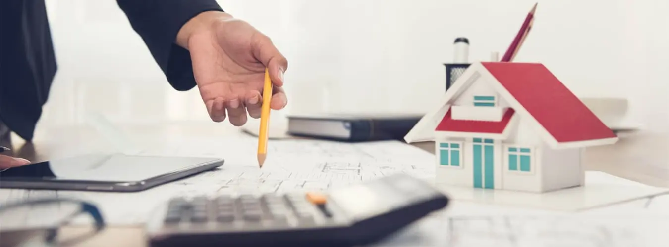 Bureau avec maison modèle, calculatrice et documents